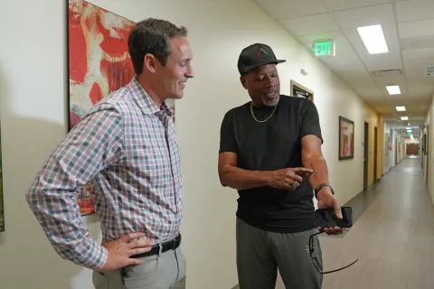 Denver Health patient Bennie Milliner shows his tattoo to cardiologist Christopher Barrett, MD, at a recent checkup following the installation of a new type of pacemaker in Milliner's heart in August.