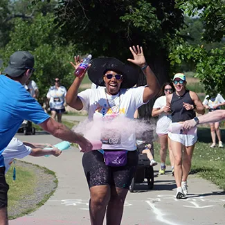 Garritte Hitchens runs through colored chalk at the Trauma Survivors Fun Run