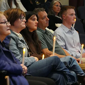 Denver Health patient Ben Varga sits at a candlelight vigil with his family.