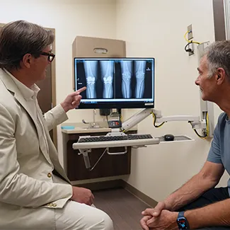 Dr. Hammerberg with a knee surgery patient looking at X-rays.