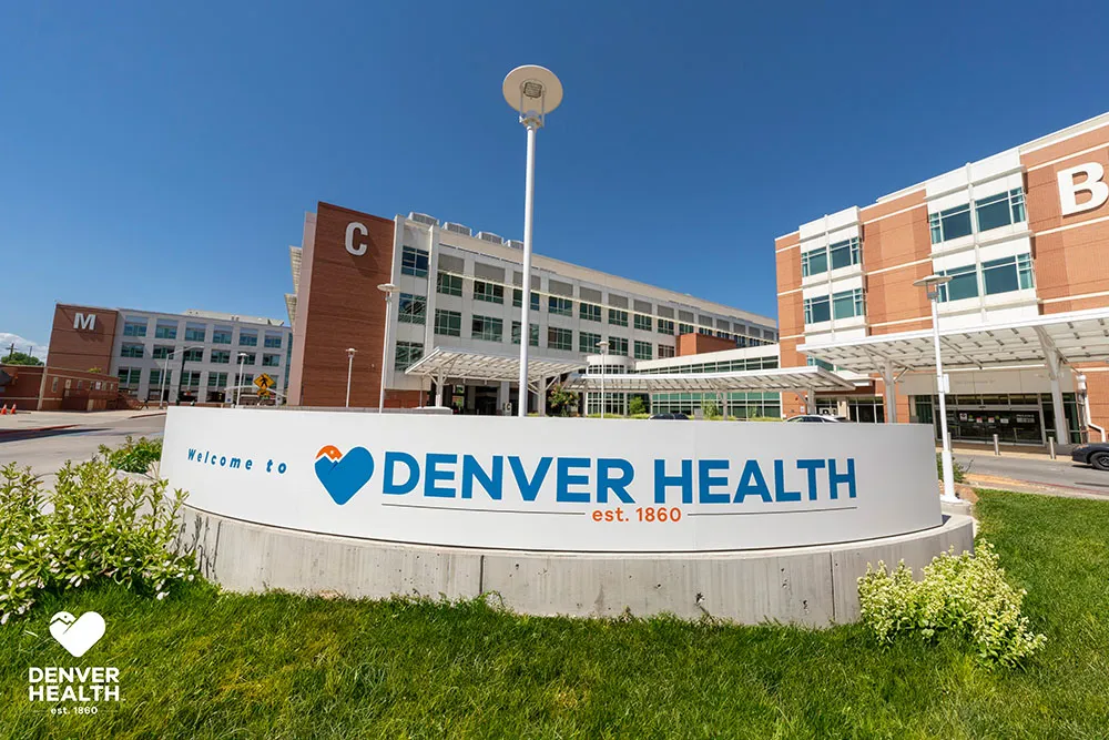 Denver Health main campus roundabout featuring green grass and the Denver Health sign.