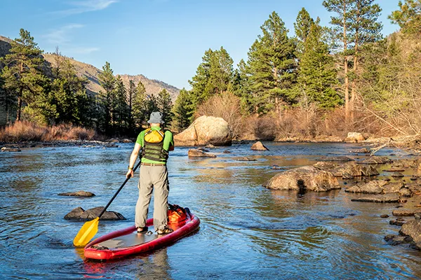 a man stands on a paddleboard